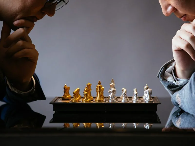 Due professionisti studiano una strategia giocando a scacchi